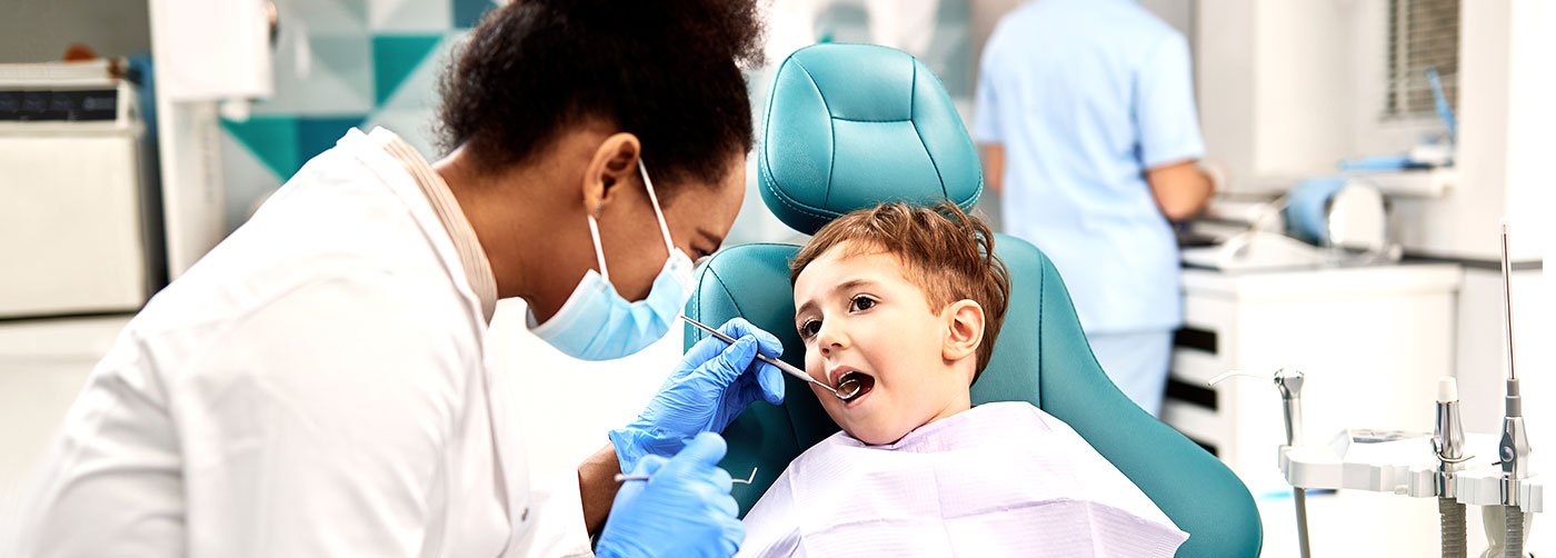 Dentist checking child's mouth in dental chair