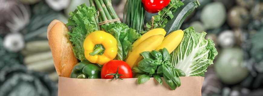 Brown grocery bag full of vegetables